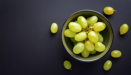 Poster - grape in a bowl on a black background, top view, copy space 