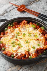 Poster - Korean Fire Chicken Cheese Buldak with gochujang paste closeup on the pan on the table. Vertical