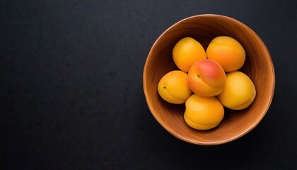 Poster - Apricot in a bowl on a black background, top view, copy space