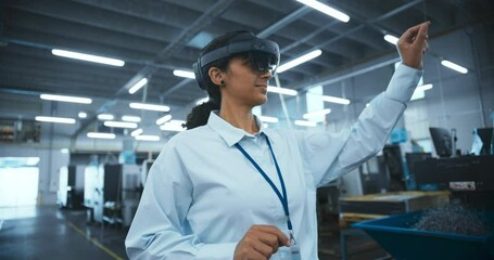 Leinwandbilder - Multiethnic Female Engineer in a Mixed Reality Headset Standing in a High Tech Manufacturing Facility, Using Modern Technology to Operate Precision Engineering Tools at a Factory