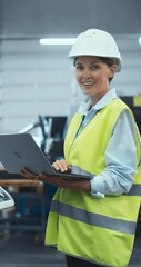 Aufkleber - Vertical Screen: Industrial Engineer at Work. Caucasian Female Using Laptop Computer to Update Settings, Downloading New Production Instructions for the CNC Machine in a High Tech Metal Factory