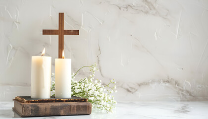 Wall Mural - Burning church candles, wooden cross, Bible and flowers on white marble table. Space for text