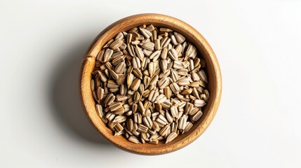 Wall Mural - Roasted unpeeled sunflower seeds in wooden bowl on white background top view