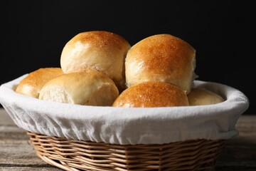 Wall Mural - Delicious dough balls in basket on wooden table, closeup