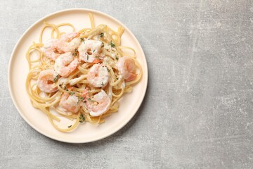 Canvas Print - Delicious pasta with shrimps on grey table, top view. Space for text