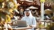 © Usman - Arabic businessman sitting in outdoor restaurant working online with laptop computer. Middle eastern man business manager using laptop, Concept of business, finance, modern technologies