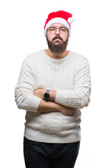 Sticker - Young caucasian man wearing christmas hat and glasses over isolated background with serious expression on face. Simple and natural looking at the camera.