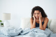 © Chanelle2000/peopleimages.com - Woman, waking up and headache or pain in bedroom with stress, worried or confused for hangover or mistake. Young African person at home massage head with migraine, morning and tired with bad memory