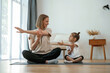 © standret - Young woman with little girl are doing yoga at home