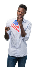 Sticker - Young african american man holding USA flag serious face thinking about question, very confused idea