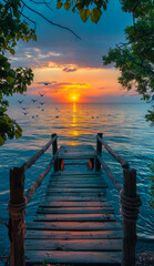 Wall Mural - A wooden pier with a wooden walkway leading to the water. The sun is setting and the sky is a beautiful mix of blue and orange.