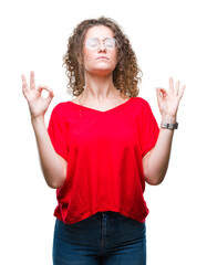 Canvas Print - Beautiful brunette curly hair young girl wearing glasses over isolated background relax and smiling with eyes closed doing meditation gesture with fingers. Yoga concept.