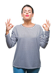 Poster - Young beautiful woman casual stripes sweater over isolated background relax and smiling with eyes closed doing meditation gesture with fingers. Yoga concept.