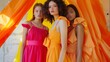 © liliyabatyrova - Three women in orange dresses pose for a photo