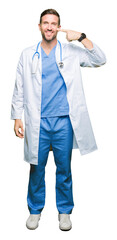 Poster - Handsome doctor man wearing medical uniform over isolated background Pointing with hand finger to face and nose, smiling cheerful