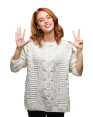 Sticker - Young beautiful woman over isolated background wearing winter sweater showing and pointing up with fingers number eight while smiling confident and happy.