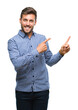 © Krakenimages.com - Young handsome man over isolated background smiling and looking at the camera pointing with two hands and fingers to the side.