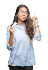 Sticker - Young arab woman holding credit card over isolated background surprised with an idea or question pointing finger with happy face, number one