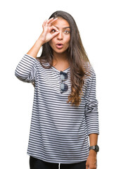 Wall Mural - Young beautiful arab woman wearing sunglasses over isolated background doing ok gesture shocked with surprised face, eye looking through fingers. Unbelieving expression.