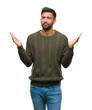 © Krakenimages.com - Adult hispanic man wearing winter sweater over isolated background clueless and confused expression with arms and hands raised. Doubt concept.