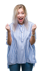 Canvas Print - Young blonde woman over isolated background celebrating surprised and amazed for success with arms raised and open eyes. Winner concept.