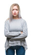 © Krakenimages.com - Young blonde woman over isolated background skeptic and nervous, disapproving expression on face with crossed arms. Negative person.