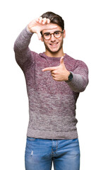 Wall Mural - Young handsome man wearing glasses over isolated background smiling making frame with hands and fingers with happy face. Creativity and photography concept.