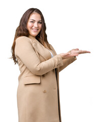 Beautiful plus size young woman wearing winter coat over isolated background Pointing to the side with hand and open palm, presenting ad smiling happy and confident