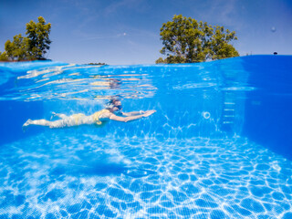 Wall Mural - woman swimming in clear blue pool