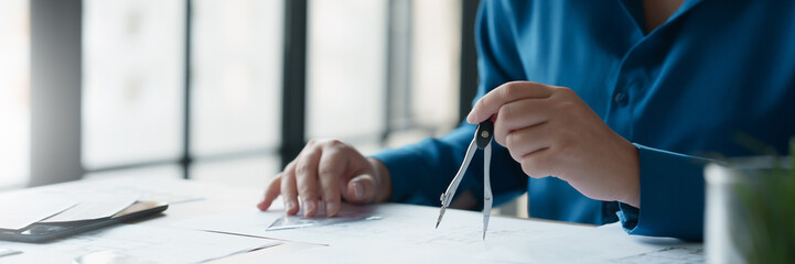 Fototapete - Architects interior designer hands working with Blue prints and documents for a home renovation for house design