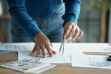 Fototapete - Architects interior designer hands working with Blue prints and documents for a home renovation for house design