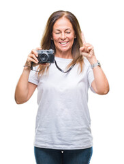 Wall Mural - Middle age hispanic woman taking pictures using vintage photo camera over isolated background surprised with an idea or question pointing finger with happy face, number one