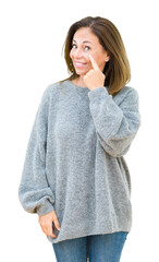 Wall Mural - beautiful middle age woman wearing winter sweater over isolated background pointing to the eye watch