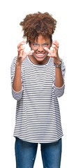 Wall Mural - Beautiful young african american woman wearing glasses over isolated background Shouting frustrated with rage, hands trying to strangle, yelling mad