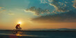 © Aigo labs - A cyclist rides towards the setting sun, creating a silhouette against the bright orange and blue sky.