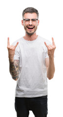 Wall Mural - Young tattooed adult man shouting with crazy expression doing rock symbol with hands up. Music star. Heavy concept.