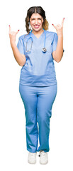 Poster - Young adult doctor woman wearing medical uniform shouting with crazy expression doing rock symbol with hands up. Music star. Heavy concept.