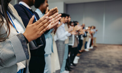 Wall Mural - Colleagues applaud at business conference presentation in workplace setting