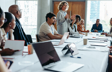 Wall Mural - confident woman leading a business meeting in a modern boardroom with diverse colleagues