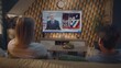 © Framestock - Caucasian couple watches news broadcast about US presidential elections and voting on the big TV display sitting on couch at home. Breaking news with male newscaster displayed on TV screen. Back view.