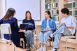 © Valerii Honcharuk - Group of teenage students with female teacher counselor inside classroom library