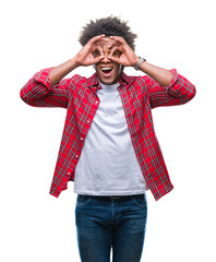 Canvas Print - Afro american man over isolated background doing ok gesture like binoculars sticking tongue out, eyes looking through fingers. Crazy expression.