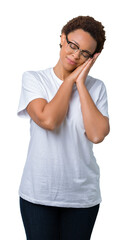 Sticker - Beautiful young african american woman wearing glasses over isolated background sleeping tired dreaming and posing with hands together while smiling with closed eyes.