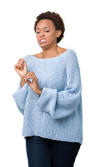 Sticker - Young beautiful african american woman wearing a sweater over isolated background disgusted expression, displeased and fearful doing disgust face because aversion reaction. With hands raised