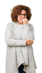 Canvas Print - Beautiful middle ager senior woman wearing jacket and glasses over isolated background looking stressed and nervous with hands on mouth biting nails. Anxiety problem.