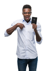 Poster - Young african american man holding australian passport with surprise face pointing finger to himself