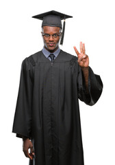 Sticker - Young graduated african american man over isolated background showing and pointing up with fingers number three while smiling confident and happy.