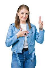 Canvas Print - Beautiful middle age mature woman wearing fashion leather jacket over isolated background Swearing with hand on chest and fingers, making a loyalty promise oath