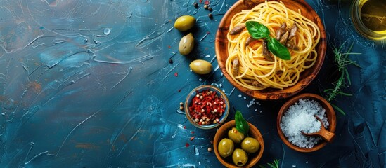 Aufkleber - An Italian plate of anchovy spaghetti with salt in a wooden bowl and olives on a blue texture background Top view with copy space image