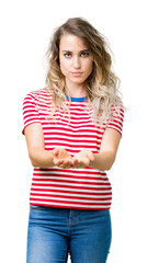 Wall Mural - Beautiful young blonde woman over isolated background Smiling with hands palms together receiving or giving gesture. Hold and protection